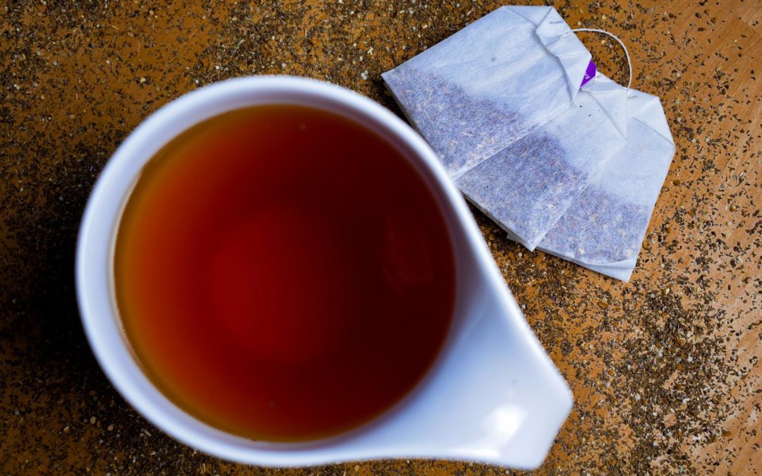 cup of medicinal tea next to tea bags